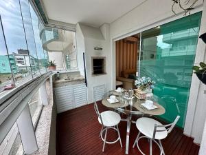 ein Esszimmer mit Tisch und Stühlen auf einem Balkon in der Unterkunft Costa do Marfim - Bombinhas in Bombinhas