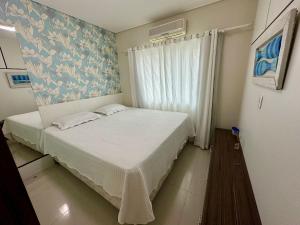 ein kleines Schlafzimmer mit einem Bett und einem Fenster in der Unterkunft Costa do Marfim - Bombinhas in Bombinhas + 9 Fotos