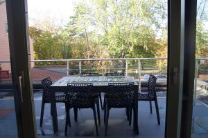d'une table et de chaises sur un balcon avec une fenêtre. dans l'établissement Apt 6 personnes terrasse vue parc, à Dunkerque