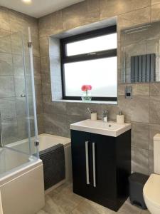 a bathroom with a sink and a toilet and a window at Newly renovated, modern bungalow - quiet location in Lytham St Annes