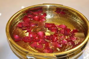 a gold bowl filled with red flowers in it at Ritvik Residency in Navi Mumbai