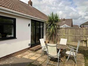 a patio with a table and chairs and a fence at Newly renovated, modern bungalow - quiet location in Lytham St Annes