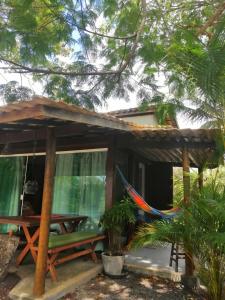 ein Haus mit einer Hängematte davor in der Unterkunft Chalé "Oasis" in Praia do Forte