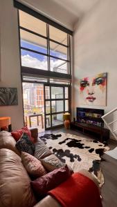 salon z kanapą i dużym oknem w obiekcie BE/SIX LOFT- Soho on Strand w Kapsztadzie