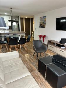a living room with a white couch and chairs at Condominio Costa Pucon in Pucón