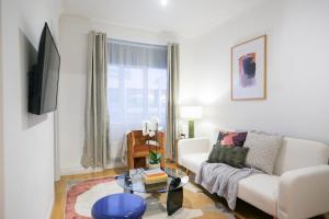 Perfectly located 1 bed apartment above tube station في لندن: غرفة معيشة مع أريكة بيضاء وطاولة