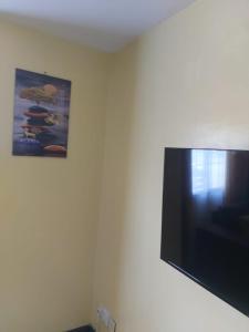 uma televisão de ecrã plano pendurada numa parede em Mrembo Lovely Nest em Nairobi
