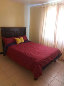 內羅畢的住宿－Mrembo Lovely Nest，卧室里一张带红色床单和黄色枕头的床