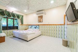 una camera da letto con un letto e una TV a schermo piatto di Summer Vibes Beach Front a Rasdhoo