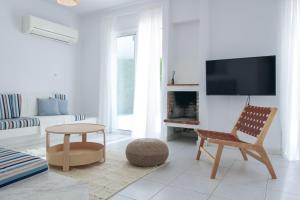 a living room with a chair and a tv at Phaedrus Living Azure Serenity Villa in Khlorakas