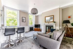 sala de estar con 2 sillas y chimenea en Pass the Keys Luxury Converted Victorian Flat in Leafy Highbury en Londres