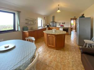 Cottage 383 - Claddaghduff في Claddaghduff: مطبخ مع طاولة وثلاجة