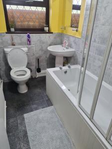 a bathroom with a toilet and a tub and a sink at The Cozy Shelter 