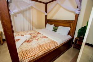 a bed in a room with a canopy bed at The Secret Garden Hotel Moshi in Moshi