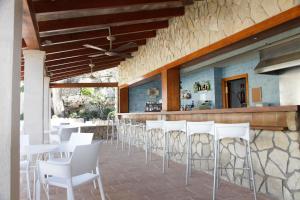 un restaurante con sillas blancas y un bar en Paz y Mar, Santa Ponsa, en Santa Ponsa