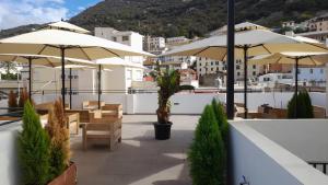 a patio with tables and umbrellas on a roof at Main Street - 3 Bed Room - Family Friendly in Gibraltar