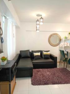 uma sala de estar com um sofá de couro preto e um espelho em Camella north point 2 bedroom em Dávao