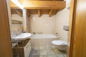 a bathroom with a tub and a toilet and a sink at Chasa Sur Chafarrer in Scuol