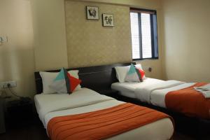 a hotel room with two beds and a window at Hotel Serene Viman Nagar in Pune