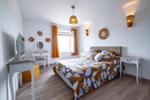 1 dormitorio con 1 cama, escritorio y TV en L'Albigeoise des Templiers - Piscine - Vue panoramique, en Cunac