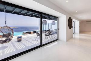a room with a large window with a view of the ocean at Psarou Black Villas in Mýkonos City