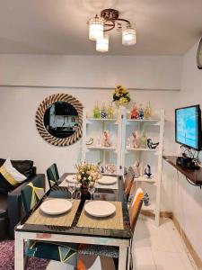 uma sala de estar com uma mesa e cadeiras e uma televisão em Camella north point 2 bedroom em Dávao