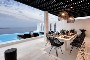 a dining room with a table and chairs at Psarou Black Villas in Mýkonos City