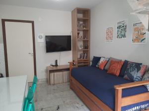 uma sala de estar com uma cama e uma televisão de ecrã plano em Loft tropical na praia de Vilas do Atlântico em Lauro de Freitas