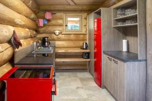 een keuken in een blokhut met een rode koelkast bij Blockhaus Almhütte Hofblick in Glatten