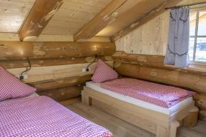 Habitación con 2 camas en una cabaña de madera en Blockhaus Almhütte Hofblick, en Glatten