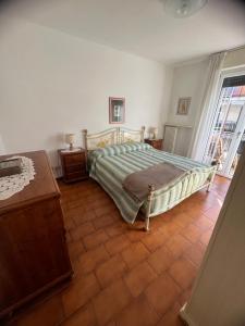 una camera con letto e pavimento piastrellato di A cà di nonni ad Albenga
