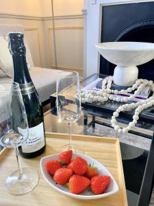une table avec un plateau de fraises et une bouteille de vin dans l'établissement Carlton House, 3 Bedroom, Cinema, Mini golf, Wifi, à Spinney Hill