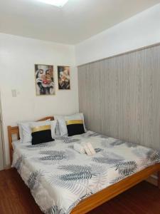 um quarto com uma cama grande e 2 almofadas em Camella north point 2 bedroom em Dávao