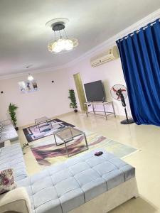 十月六日城的住宿－فيلا بحمام سباحه，带沙发和蓝色窗帘的客厅