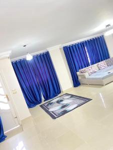 10月6日市にあるفيلا بحمام سباحهのリビングルーム(青いカーテン、ソファ付)