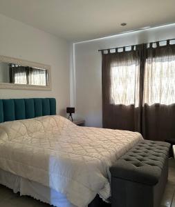 1 dormitorio con 1 cama, 1 silla y ventanas en Departamento chic en el corazón de Mendoza en Mendoza