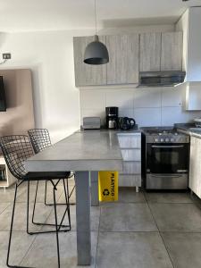 uma cozinha com uma mesa com 2 cadeiras e um fogão em Departamento chic en el corazón de Mendoza em Mendoza