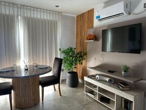 ein Wohnzimmer mit einem Tisch und einem Flachbild-TV in der Unterkunft Departamento chic en el corazón de Mendoza in Mendoza