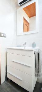 bagno con lavandino bianco e specchio di Apartamento con vistas en Pedras Negras a Pontevedra