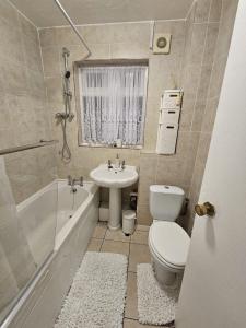 a bathroom with a sink and a toilet and a tub at Superb One bedroom house in Thamesmead