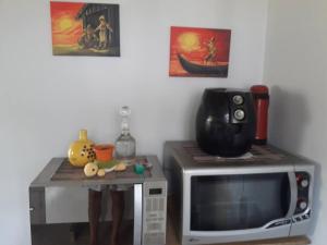 a microwave with a table on top of it at Casa próximo a praias, trilhas e cachoeiras. in Garopaba