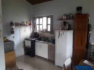eine Küche mit einem Kühlschrank und einem Herd in der Unterkunft Casa próximo a praias, trilhas e cachoeiras. in Garopaba