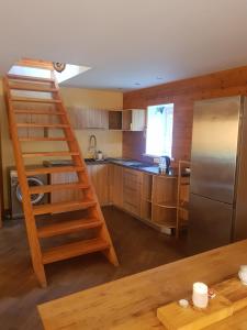 cocina con escalera y nevera de acero inoxidable en Čapuliši, en Kandava