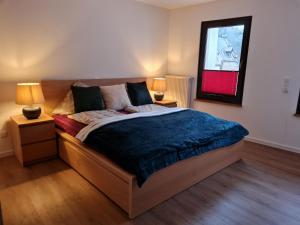 een slaapkamer met een bed met 2 lampen en een spiegel bij Ferienhaus Take it easy in Traben-Trarbach