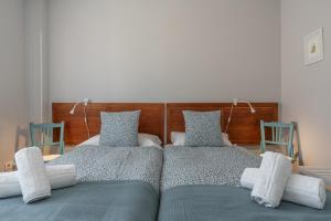 two beds in a bedroom with two blue chairs at tuGuest Armilla House in Armilla