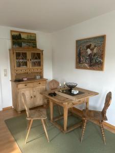 una sala da pranzo con tavolo in legno e 2 sedie di Ferienwohnung An der Loipe a Lichtenstein