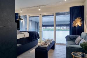 a bedroom with a bed and a couch and a window at Captains Boathouse Studio in Harderwijk