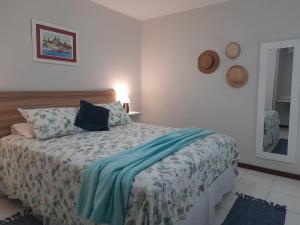 a bedroom with a bed with a blue blanket on it at Loft tropical na praia de Vilas do Atlântico in Lauro de Freitas