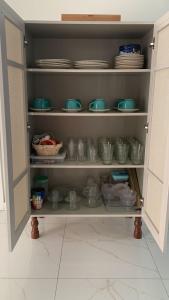 a cupboard filled with dishes and plates in a kitchen at Casa na Praia de Ponta Negra in Natal
