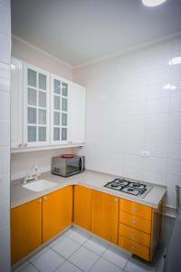 uma cozinha com um fogão, um lavatório e um micro-ondas em Apto com WiFi no centro de Aguas De Lindoia SP em Águas de Lindoia